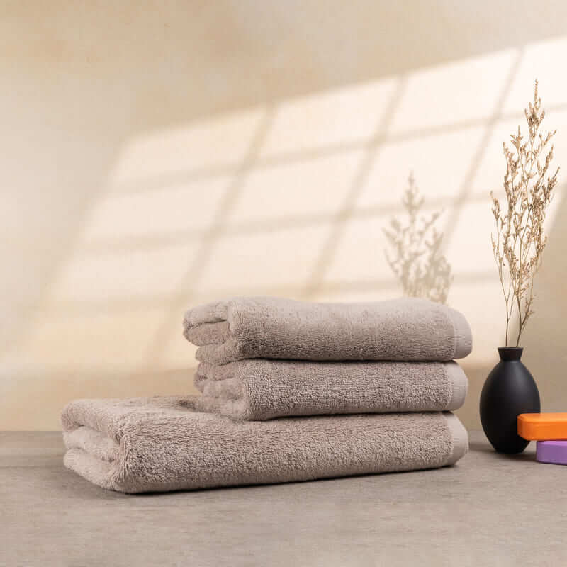 Set aus 3 weichen Handtüchern in Cashmere-Optik, gestapelt – mit neutralen Tönen und elegantem Design, perfekt für ein luxuriöses Bad.