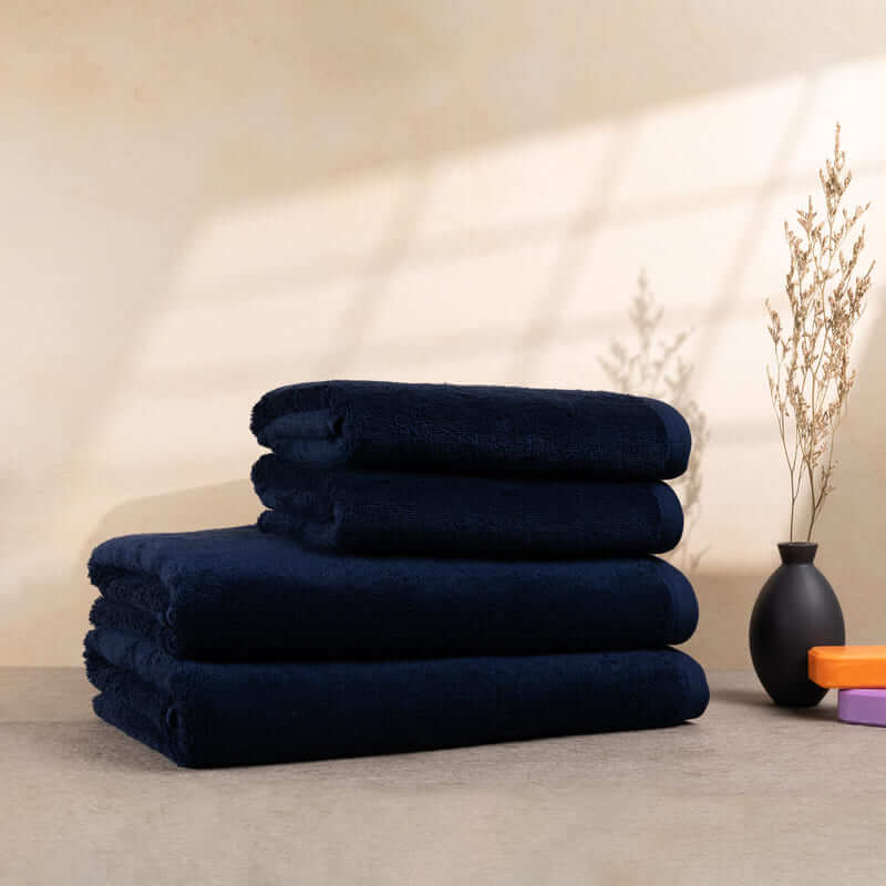 Set aus 4 dunkelblauen Handtüchern, ordentlich gestapelt – ideal für Badezimmer-Deko und den täglichen Gebrauch.