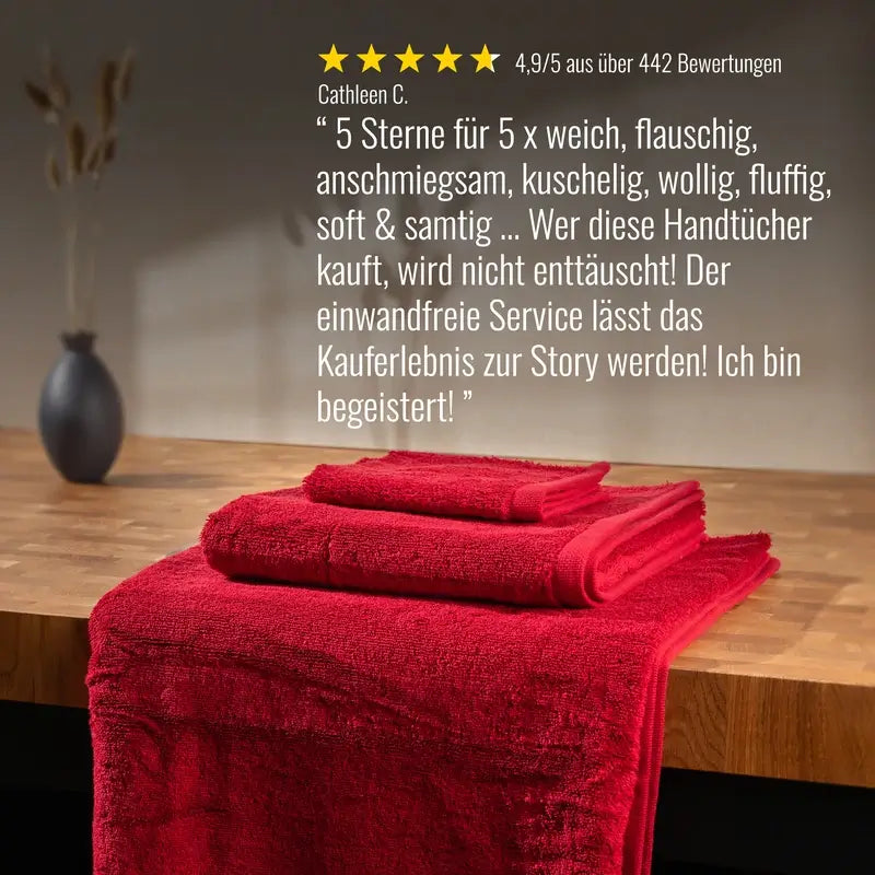 Bomlins rotes 4er Set aus zwei Handtüchern und zwei Duschtüchern auf einer Holzoberfläche mit eingeblendeter 5 Sterne Bewertung von Kundin Cathleen C.