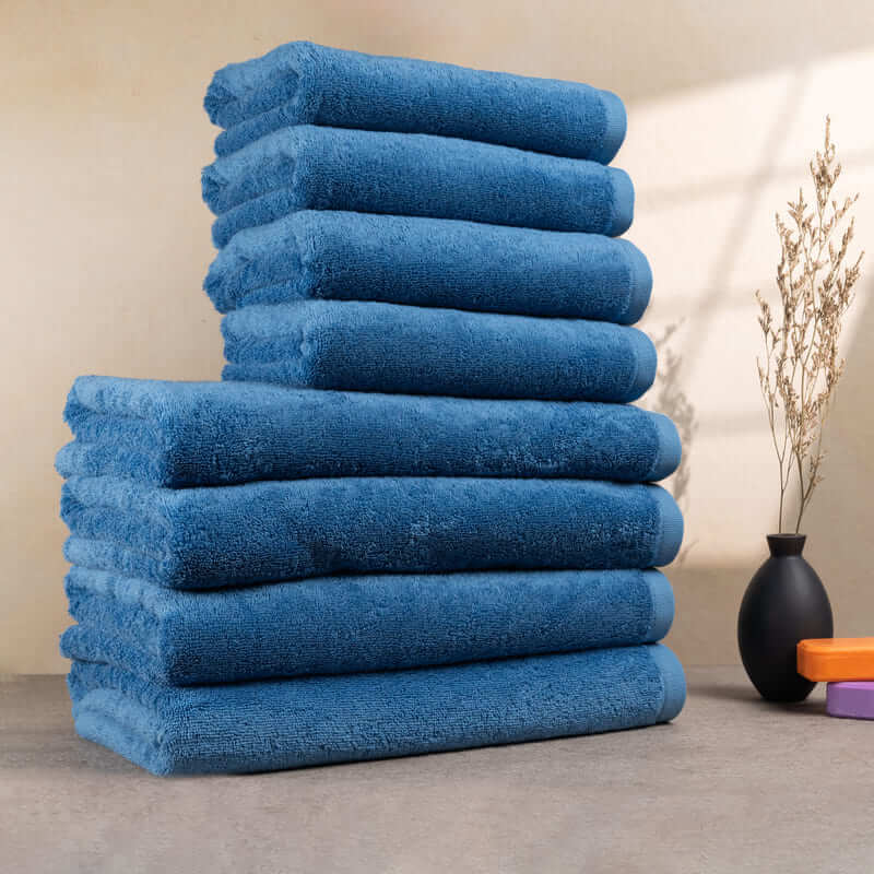 Set aus 8 hellblauen Handtüchern, ordentlich gestapelt – mit weicher Struktur und kräftiger Farbe.